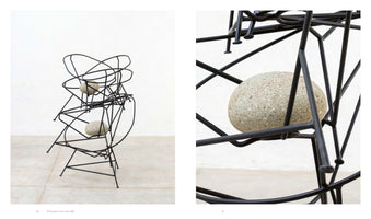 A two-panel image of a contemporary sculpture. On the left, a full view of a tall, abstract structure made of black metal rods resembling a stack of chairs, with two large, gray stones placed within it. On the right, a close-up shot of one of the speckled gray stones nestled among the intersecting black rods.