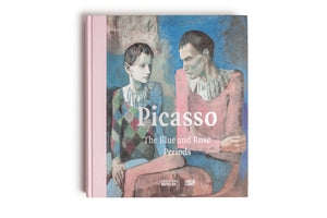 A top-down photo of a hardcover book with a pink spine on a white background. The cover features a painting of two pensive figures and has the title Picasso, The Blue and Rose Periods printed in white text. The logos for Fondation Beyeler and Hatje Cantz are at the bottom.