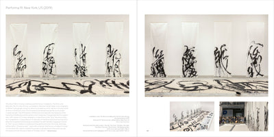 A two-page book spread showing an art installation from Performa 19 in New York. In a white gallery space, several large vertical banners and a long horizontal scroll on the floor are covered with expressive, large-scale black ink calligraphy. The spread includes descriptive text and smaller inset photos of the installation.