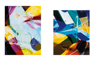 A two-page spread displaying two vibrant abstract artworks. The piece on the left features a layered collage of translucent yellow, magenta, and light blue shapes with white, spiraling lines. The piece on the right is a composition of sharp, crystalline forms in deep blue, cyan, and yellow.