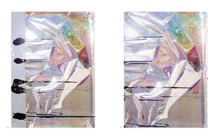 An abstract diptych showing two pages from a book. Each page features a piece of crinkled, iridescent silver foil that reflects a rainbow of colors. Thick, horizontal lines and splatters of black paint are layered over the foil.