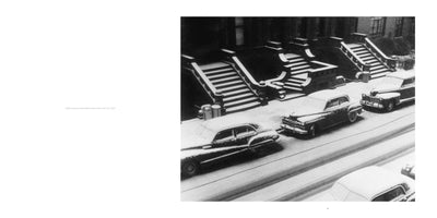 A black and white 1952 photograph of a New York City street from a high angle after a snowfall. Several vintage cars are parked in a row along the curb, and the stoops of the adjacent buildings are all covered in a thick blanket of snow.