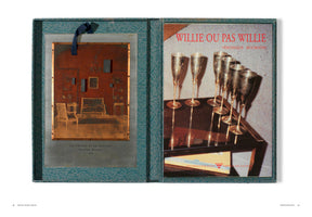 An open, turquoise textured portfolio box displaying two artworks by Véronique Bourgoin. On the left, a sepia-toned artwork of a formal room interior with a plaque titled Le Discret et le Continu. On the right, a grainy photograph of six champagne flutes on a bar cart with the title Willie ou Pas Willie.