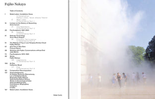 A two-page spread from a book about artist Fujiko Nakaya. On the left is the table of contents, listing chapters like Fog Sculptures. On the right is a full-page photo of an outdoor art installation, showing a group of people standing in a thick cloud of white fog that fills a sunny plaza.