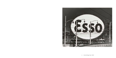 A black and white photograph from 1970 titled Granville Bridge Esso. The image shows a large, circular Esso sign in an urban industrial setting. The sign is partially obscured by a network of streetlights, utility poles, and wires, with the railing of a bridge visible in the foreground.