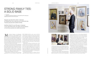 A two-page magazine spread with the headline STRONG FAMILY TIES: A SOLID BASE. The right page features a large photo of an elderly man in a dark suit and glasses, standing in front of a wall adorned with numerous framed family portraits from different generations. He is pointing to one of the older, sepia-toned portraits. The spread contains text in both English and German.