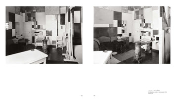 A two-page book spread showing two black-and-white photographs of Piet Mondrian's studio from 1925-26. The walls are covered in a geometric arrangement of black, white, and grey rectangular panels, characteristic of De Stijl. The room is furnished with an easel, a sofa, chairs, and an ornate stove, capturing the artist's integrated living and working environment from slightly different angles.
