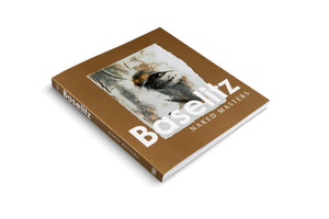The art book Baselitz: Naked Masters is shown at an angle on a white background. Its solid brown cover features the title in bold white text below a close-up, expressive, painterly image of a face, focusing on an eye. The spine of the book is also visible.