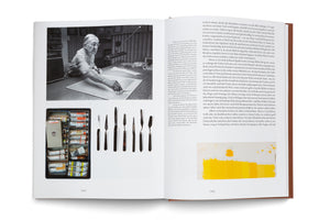 An open art book displays a two-page spread about artist Josef Albers. The left page features a black-and-white photo of Albers painting, a color photo of his paint box, and a row of palette knives. The right page contains a color study with various swatches of yellow paint. Both pages include blocks of German text.