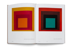An open art book displaying two of Josef Albers' abstract paintings from his Homage to the Square series. The painting on the left page features nested squares in warm tones of yellow, red, and orange. The painting on the right shows squares in shades of red, brown, and black surrounding a central teal square.