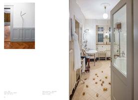 A two-page spread from an art publication. On the left, a tall, thin, stick-like metal sculpture stands in a room with herringbone wood floors and gray wainscoting. On the right, a photograph shows a vintage-style bathroom with white tiled walls, where dozens of peeled potatoes are scattered across the floor.