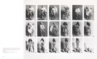 A black and white photo series presented as a grid of 18 images. It documents a performance where a woman with long dark hair performs a striptease using voluminous white sheets. She begins completely concealed by the fabric, creating dramatic, sculptural poses. Frame by frame, she removes the sheets, culminating in her standing nude on the discarded pile. The final frame shows only the empty pile of sheets, the woman having disappeared.