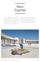 A page from a publication titled New Capital, featuring an article and a large photograph. The photo shows construction workers on a vast, paved plaza in Egypt's New Administrative Capital. In the foreground, a worker in a blue shirt shovels sand. In the background stands a monumental, neoclassical building with tall white columns, reminiscent of an Arc de Triomphe, under a clear blue sky.