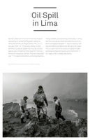 A black and white photograph of three workers in oil-stained protective suits and respirators carefully walking over a rocky shore next to the hazy ocean. They are part of the cleanup effort for the 2022 Repsol oil spill in Lima, Peru.