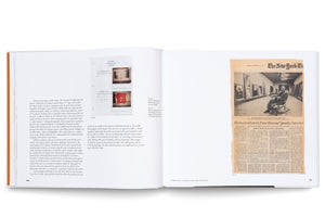 An open art book on a white surface, showing pages 50 and 51. The left page has text and two Polaroid photos of abstract red paintings. The right page features a reproduction of a New York Times article from 1976, with a large black-and-white photo of artist Robert Motherwell sitting in a rocking chair in a gallery.