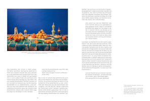 An open book showing a two-page spread with German text. The left page features a large color photograph of a still life. On a table with a blue and green patterned cloth, dozens of tangerines, some peeled, are arranged with several sculptural vases against a solid, deep blue background.