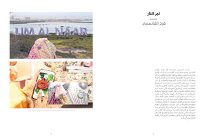A two-page magazine spread in Arabic titled أم النار by فرح القاسمي. On the right, two photographs are stacked above a text block. The top photo shows a person in a colorful floral covering sitting on a hill in front of a large purple sign that reads UM AL NAAR, overlooking a body of water and a city. The bottom photo is a close-up of a person holding a smartphone, which displays an image of a red, edible-looking rose.