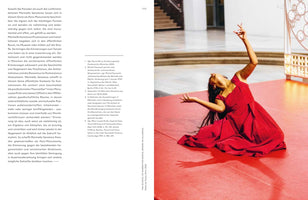 A two-page spread from a publication. The left page contains a block of German text with numbered footnotes. The right page features a large color photograph of a woman with long dark hair, wearing a flowing red dress, performing on a red floor. She is kneeling and arching her back dramatically, her arms raised in an expressive pose inside a bright, modern gallery space.