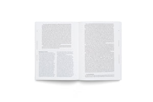 A high-angle shot of a book lying open on a white surface. The pages, numbered 32 and 33, display German text in a neat, multi-column layout.