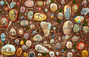 A flat lay photograph of a dense collage made of painted stones, twigs, and moss on a reddish-brown surface. The stones are intricately painted with a wide variety of subjects, including human figures, skeletons, surreal creatures, and colorful abstract patterns, creating a complex and detailed piece of folk art.