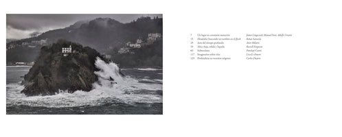 A two-page book spread. The left page features a dramatic, monochromatic photograph of a stormy sea, with large white waves crashing against a rocky island topped with a small house. A misty, populated hillside is in the background under a cloudy sky. The right page displays the book's table of contents in Spanish, listing chapter titles and authors.