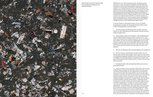 An open book displays a two-page spread. The left page is a full-bleed, top-down photograph of dark pavement covered in a dense layer of trampled trash, paper scraps, and confetti. The right page features German text formatted as an interview, with the page number 129 at the bottom.