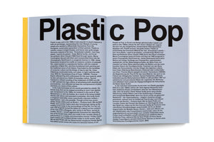 An overhead shot of an open book with light blue-gray pages. Across the top of the spread, the title Plastic Pop is printed in a large, bold, black font. Below the title are two columns of text, one in English and the other in German. A sliver of a yellow page is visible on the left.