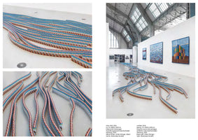 A composite image showing a large-scale art installation in a gallery from three different perspectives. The main photo on the right displays the full installation, where thousands of cocoa milk cartons are arranged in long, serpentine lines that flow across the white floor like rivers or tracks. Two smaller close-up photos on the left show details of the parallel and curving arrangements of the cartons.