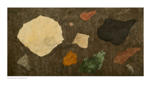 A horizontal abstract artwork titled Das grosse Prag / Great Prague, 2012. The piece is a collage of irregularly shaped, paper-like fragments in earthy tones, scattered across a dark, mottled brown background. The fragments include a large, pale yellow shape on the left, a large black shape on the right, and smaller pieces in orange, green, red, and grey.