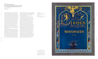 A two-page book spread displays Karl Friedrich Schinkel's 1815 design for the book title Lieder der Wehmuth. The artwork on the right page has a deep blue background with the title in gold Gothic script. It is framed by an ornate gilded border with intricate details and small figures. At the top, a golden eagle sits on an arch, and at the bottom, a silhouetted man plays a lute by the water at night. The left page contains explanatory text in German.