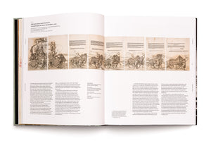 An overhead shot of an open art history book laid flat on a white surface. The two-page spread displays Albrecht Dürer's multi-panel woodcut, The Triumphal Chariot of Maximilian I, running horizontally across the top. The detailed print shows an ornate chariot pulled by a long procession of twelve horses. The rest of the pages are filled with columns of descriptive German text.