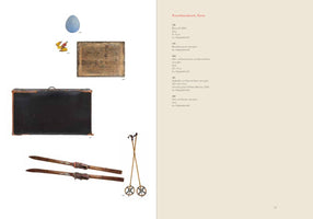 A two-page catalog spread with a cream-colored background, titled Kunsthandwerk, Varia in red text. The left page displays five numbered objects: a light blue egg, several small pencil stubs, a worn wooden drawing board, a large black art case with a handle, and a pair of vintage wooden skis and poles. The right page lists the corresponding descriptions for each object in German.