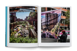 An open book on a white surface displays a two-page photo spread. The left page shows an architectural rendering of a modern brick housing complex with lush green spaces, which is actually a large banner attached to a real construction site. The right page shows a man on a city street holding a large, rippling banner that depicts a rendering of a different modern building at night.