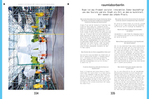 A two-page magazine spread with German text. The left page features a large, vertically oriented photograph of an outdoor art installation. In the photo, several people in workwear maneuver a large, white, segmented inflatable structure in front of a multi-story metal scaffolding filled with various colorful objects, including a yellow car part. The right page consists solely of text.