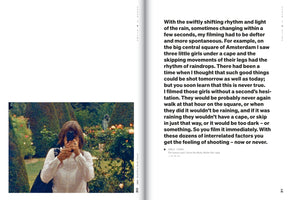 A two-page spread from a book. The left page features a grainy, color photograph of a woman with brown hair holding a vintage camera to her face in a lush garden with flowers. The right page contains a large block of text about the spontaneous nature of filming.