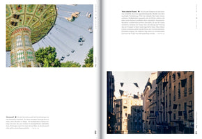 An open book showing a two-page spread with photographs and German text. The left page has a color photo of an ornate green swing carousel in motion. The right page has a color photo of a narrow city street with black triangular flags strung between buildings.
