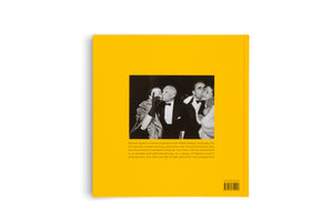 The back cover of a book with a vibrant yellow background, shown against a white surface. In the center is a black-and-white photograph of Pablo Picasso in a tuxedo at a party, smiling as he is surrounded by friends. Below the image is a paragraph of text, and a barcode is in the bottom-right corner.
