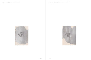 A two-page spread from an art book, pages 96 and 97, against a white background. Each page features an identical small, vertical artwork consisting of a rectangular piece of paper with a textured, metallic silver swatch of paint. A small, dark, abstract hangtag shape is impressed into the center of the silver area on each piece.