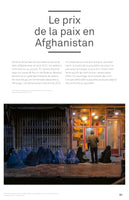 A nighttime photograph from Kabul shows a group of women and children in blue burqas sitting and begging on the sidewalk in front of a brightly lit bakery. Inside the shop, which is filled with bread, a man stands at the counter. The image is part of a French-language article titled Le prix de la paix en Afghanistan.