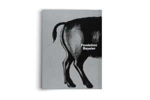 A vertically oriented book with a grey cover against a white background. The cover features a black-and-white illustration of the hindquarters of a farm animal, possibly a bull, with its tail and back legs visible. The words Fondation Beyeler are written in white on the animal's flank.