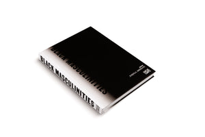 A high-angle shot of the book Black Masculinities, edited by Joshua Amissah and published by Hatje Cantz. The hardcover book has a minimalist black and white design, with the title in a bold, sans-serif font on the cover and spine, and is displayed on a white surface.