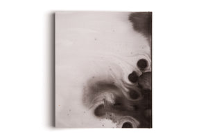 A rectangular, vertically oriented canvas with an abstract ink wash painting. On the off-white textured surface, dark black ink bleeds from the right edge, forming soft, circular blooms and smoky swirls that spread toward the center. The canvas is set against a plain white background, casting a subtle shadow.