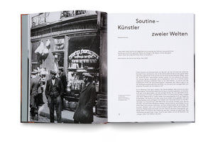 An open book with a two-page spread. The left page shows a vintage black-and-white photograph of several men in hats and coats standing outside a shop with Hebrew lettering on the window. The right page is white with black German text, titled Soutine – Künstler zweier Welten.