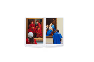 An open book on a white background displaying two photos of museum-goers whose outfits coincidentally match the artwork they are viewing. On the left, a woman in a red sweater and white beret looks at a painting of three girls in red dresses. On the right, a person in a bright blue poncho stands before a painting of the Madonna and Child, where Mary wears a similarly colored blue robe.