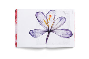 An open book viewed from above on a white background, displaying a large illustration of a translucent purple flower with delicate veins and a yellow and orange center across the two-page spread. The edges of the book have a red and white textured pattern.
