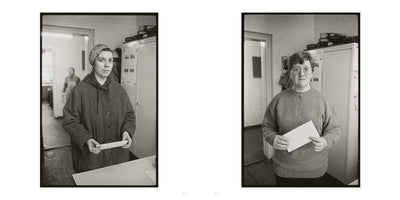 A side-by-side pair of black and white portraits. On the left, a woman in a dark coat and headscarf holds a piece of paper. On the right, a woman with glasses and a knit sweater holds an envelope. Both stand in an office-like setting and look directly at the camera with neutral expressions.