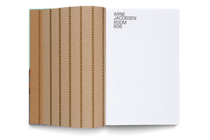 A high-angle shot of an open book on a white background. The left page is light brown with a pattern of vertical stripes made of repeating semi-circles. The right page is white, with the text ARNE JACOBSEN ROOM 606 printed in a black sans-serif font in the upper left corner.