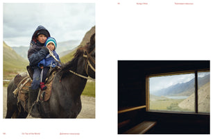A two-page spread from a book. The left page shows two young children in winter clothes riding together on a dark horse in a mountain valley. The right page shows a view of a similar mountain landscape with a lake, seen through a window from a dark room.