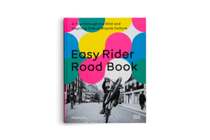 The cover of the book Easy Rider Road Book, subtitled A Tour through the Wild and Inspiring Side of Bicycle Culture. The design features large, overlapping circles in bright pink, yellow, and blue over a black and white photograph of a person doing a wheelie on a bicycle on a city street.