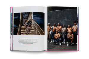 An open photobook on a white surface. On the left page, people carry lowrider bikes down outdoor stairs above a quote. The right page is a full-bleed photo of a group of tattooed Latino men, mostly shirtless, posing against a dark, textured wall.